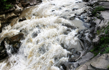 A powerful stream of a mountain river above the stones.