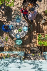 Fototapeta premium Top view, at home a family prepares a barbecue on a terrace, the father shows his son how to take care of the grills.