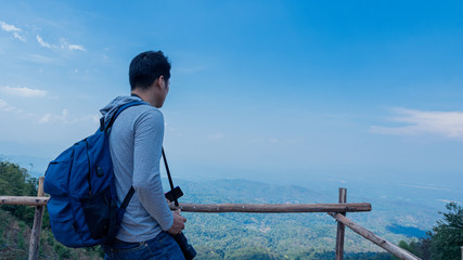 Naklejka premium A man standing at the beautiful view of Doi Mon jam, a tourist attraction in Chiang Mai, Thailand