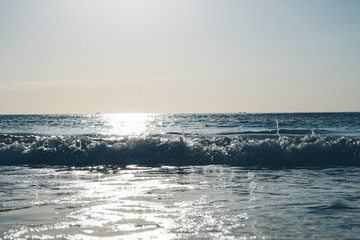 Sunrise at sea. Wave on sea. Beach scene in summer. Summertime morning. Grey color. Nobody. Water spray in sunny day. Seascape without people. Maritime landscape. Walking around сoast. Pacific ocean.