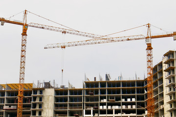 Two cranes near building. Building under construction. Construction site.