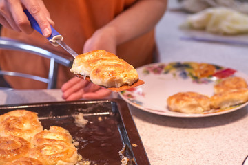 Woman taking delicious homemade pies from table, top view