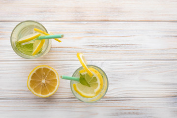 Summer drink lemonade on a white wooden table, top view, space for text