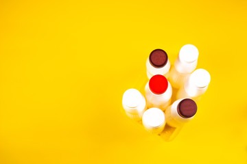 Empty plastic yogurt bottles on a yellow background. Collection of waste food plastic packaging. Concept of plastic recycling environmental Ecology. Top view with copy space
