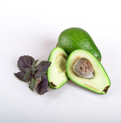 half avocado with a branch of fresh red Basil with a knife, isolated on a white background