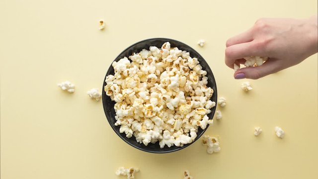 Stop motion animation, cheesy popcorn take hands and eat