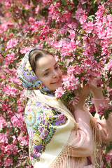 Russian fashionable girl in vintage Pavlovo Posad shawl. Pink flowers of blossoming apple-tree,...