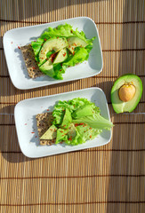 crispbread with salad and avocado on a white plate top view. Healthy healthy diet Breakfast vertical photo