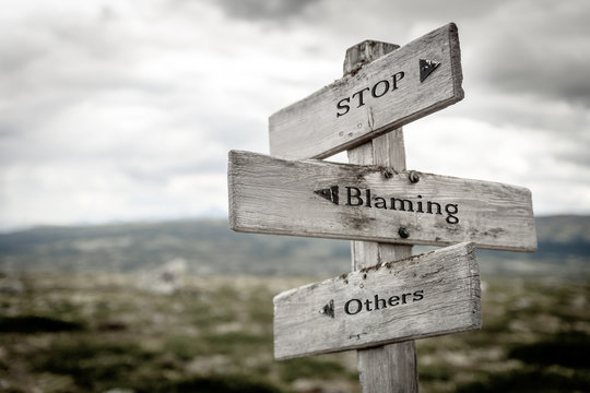 stop blaming others text engraved on old wooden signpost outdoors in nature. Quotes, words and illustration concept.