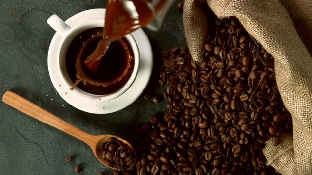 Super slow motion of pouring coffee into cup, high angle view. Filmed on high speed cinema camera, 1000fps.