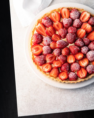 a dessert of strawberry tart on a light marble backdrop