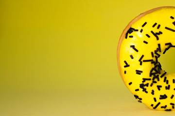 half a doughnut in the right corner on a yellow background, a lot of free space for text, for your presentation slides or screensavers