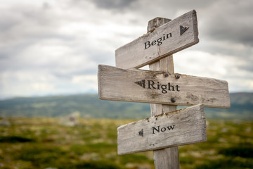begin right now text engraved on old wooden signpost outdoors in nature. Quotes, words and illustration concept.