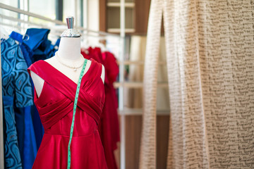 Selective focus of dummy mannequin with measuring tape in tailors studio. Concept of dressmaking and fashion.