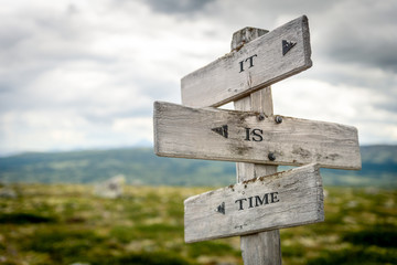 it is time text engraved on old wooden signpost outdoors in nature. Quotes, words and illustration concept.