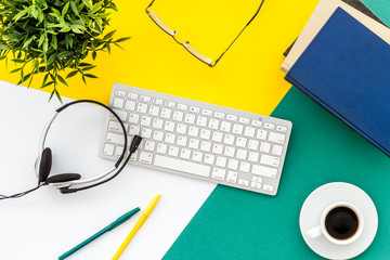 Online education. Books, computer and headphones on colorful background top-down