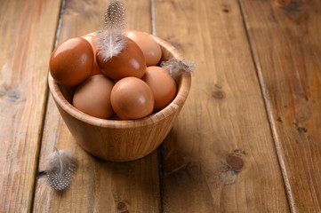 rustic eggs, from homemade chickens, on a wooden background, with feathers. Eco foods, clean food. Vintage photo. The concept of natural food. Copy space