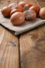 rustic eggs, from homemade chickens, on a wooden background, with feathers. Eco foods, clean food. Vintage photo. The concept of natural food. Copy space