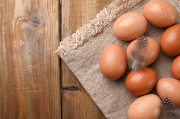 rustic eggs, from homemade chickens, on a wooden background, with feathers. Eco foods, clean food. Vintage photo. The concept of natural food. Copy space