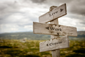 live work create text engraved on old wooden signpost outdoors in nature. Quotes, words and...