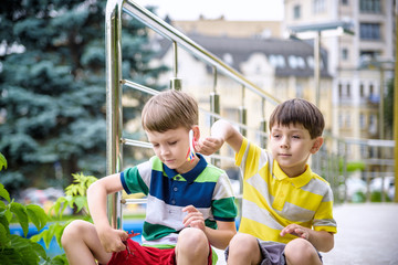 Happy two brother kids playing with toy airplane on warm summer day. Boys look at scale copy of plane. Best childhood and travel friendship concept