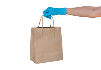 Hand wearing blue glove for protect allergic reaction or infectious diseases coronavirus/covid-19 holding paper bag deliver goods to customer isolated on white background, clipping path included