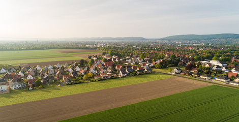Fototapeta na wymiar Luftaufnahme von Feldern mit einer Kleinstadt im Hintergrund