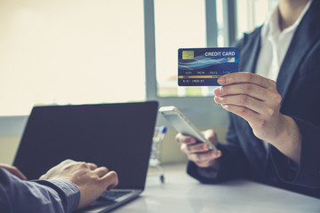 Both business people use laptop and phones to register online purchases using credit card payments, Convenience in the world of technology and the internet, Shopping online and banking online concept.