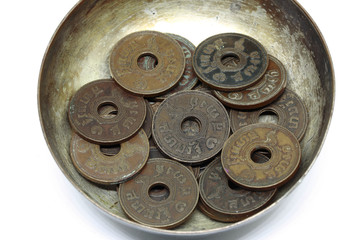 Close-up old Thailand coin in the old silver bowl.