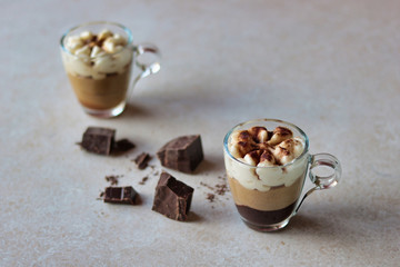 two coffee cream cups with cocoa powder