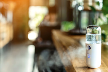 Alcohol nano mist sprayer for hand cleaning to prevent the spread of the corona virus (Covid-19) placed on the table to serve customers before buying in the coffee shop. Modern health technology.