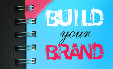 Create your brand text message words on sky blue page of copyybok in white and pink. Business...