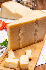 Fototapeta na wymiar Big wedges of parmigiano-reggiano parmesan hard Italian cheese made from cow milk or Grana Padano