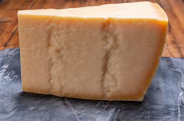 Big wedge of parmigiano-reggiano parmesan hard Italian cheese made from cow milk or Grana Padano