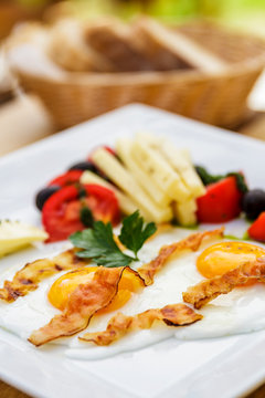 Bacon fried eggs with salad