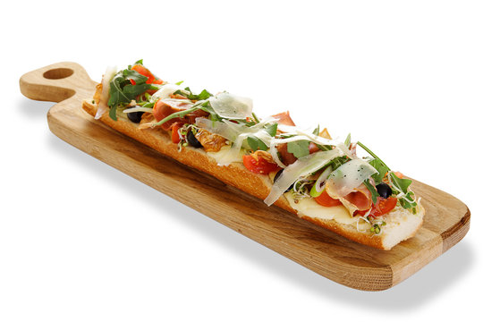 baguette bruschetta ham with arugula cheese cherry tomato on wooden plate isolated background