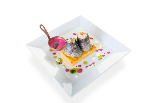 fish fillet with polenta and beetroot sauce on white isolated background