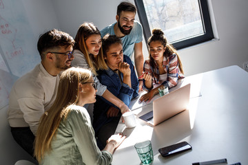 Group of programmers and designers in a conference room. They're discussing development of a new...