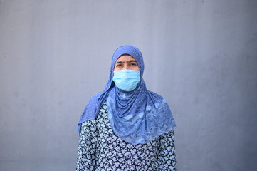 Young beautiful Muslim woman in medical mask,looking at camera. Health care and medical concept. Stay at home quarantine coronavirus pandemic prevention.