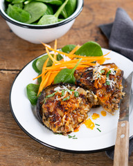 Eggplants Stuffed with Beef, rice and Vegetables with garnish carrot strips, spinach over rustic table, selective focus.