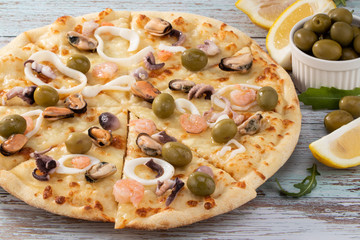 seafood pizza with olives on wooden background