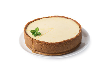 Plane round classic New York cheesecake with sprig of mint on a plate isolated on white background