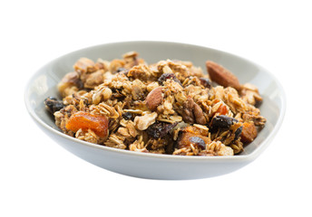Morning breakfast with granola in a ceramic bowl isolated on white background. Side view.