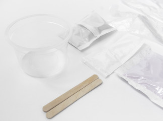 Close up of medical experiments. transparent jar, three pockets with reagents, medical gloves on isolated light background. Experiments for kids. Selective focus
