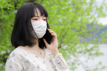 スマホで通話するマスク姿の女性