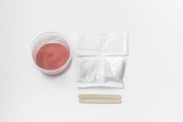 Close up of medical experiments. transparent jar, three pockets with reagents, medical gloves on isolated light background. Experiments for kids. Selective focus