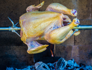 Slowly rotating chicken on a grill.