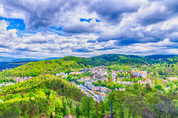 Fototapeta na wymiar Top aerial panoramic view of Karlovy Vary (Carlsbad) spa town with colorful beautiful buildings, Tepla river and hills of Slavkov Forest with green trees, West Bohemia, Czech Republic
