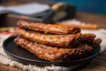 Marinated spicy duck neck on a black plate is extremely delicious to some people.