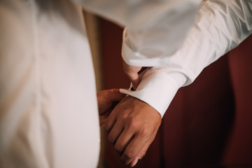 Obraz na płótnie Canvas photo of a groom wearing shirt buttons